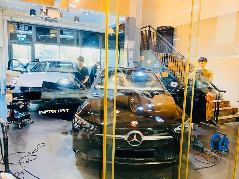 Silver Porsche Macan and black Mercedes-Benz CLA being tinted at Infratint Singapore