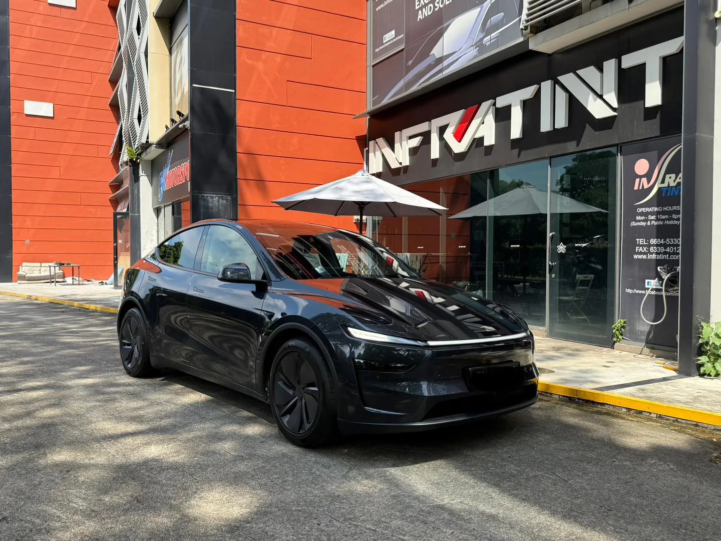 Dark Tesla Model Y Juniper front three-quarter view with tinted windows at Infratint Singapore