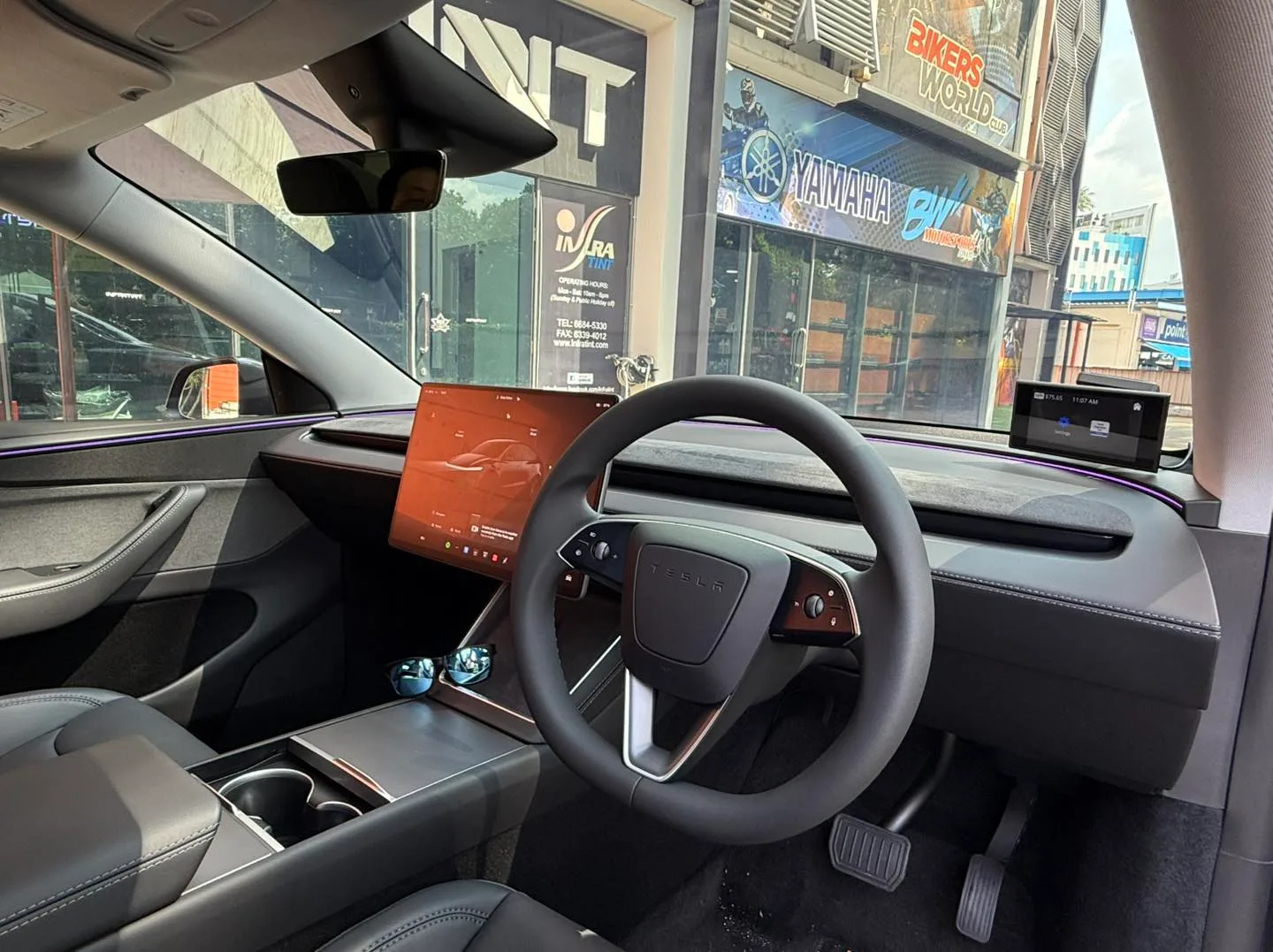 Tesla Model Y Juniper interior with central touchscreen seen through tinted glass at Infratint Singapore