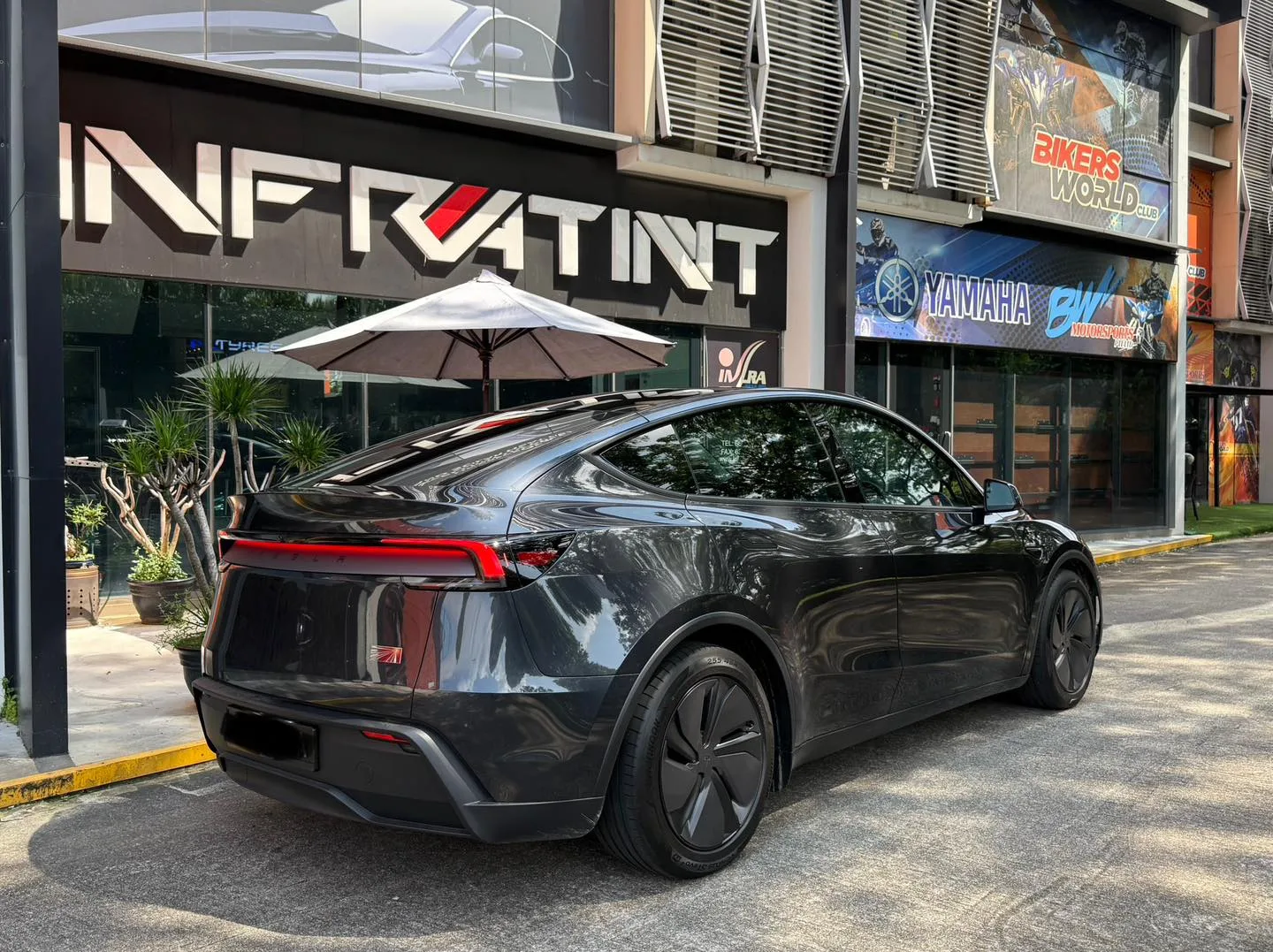 Tesla Model Y Juniper rear three-quarter view with tinted glass and light bar at Infratint Singapore