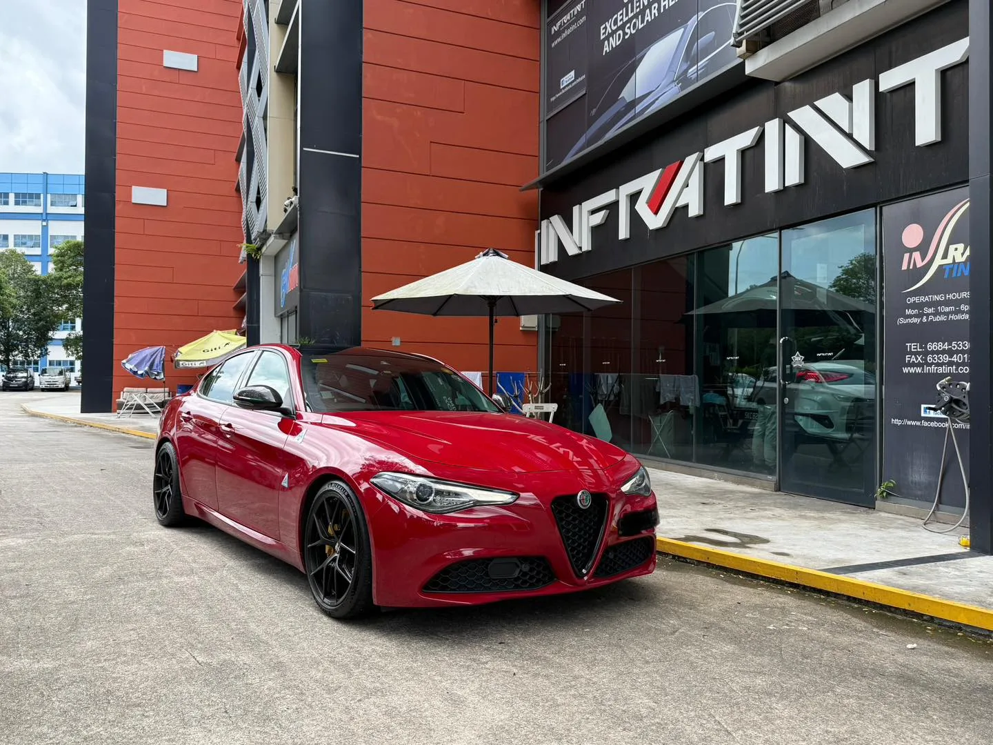 Red Alfa Romeo Giulia front three-quarter view with tinted glass at Infratint Singapore