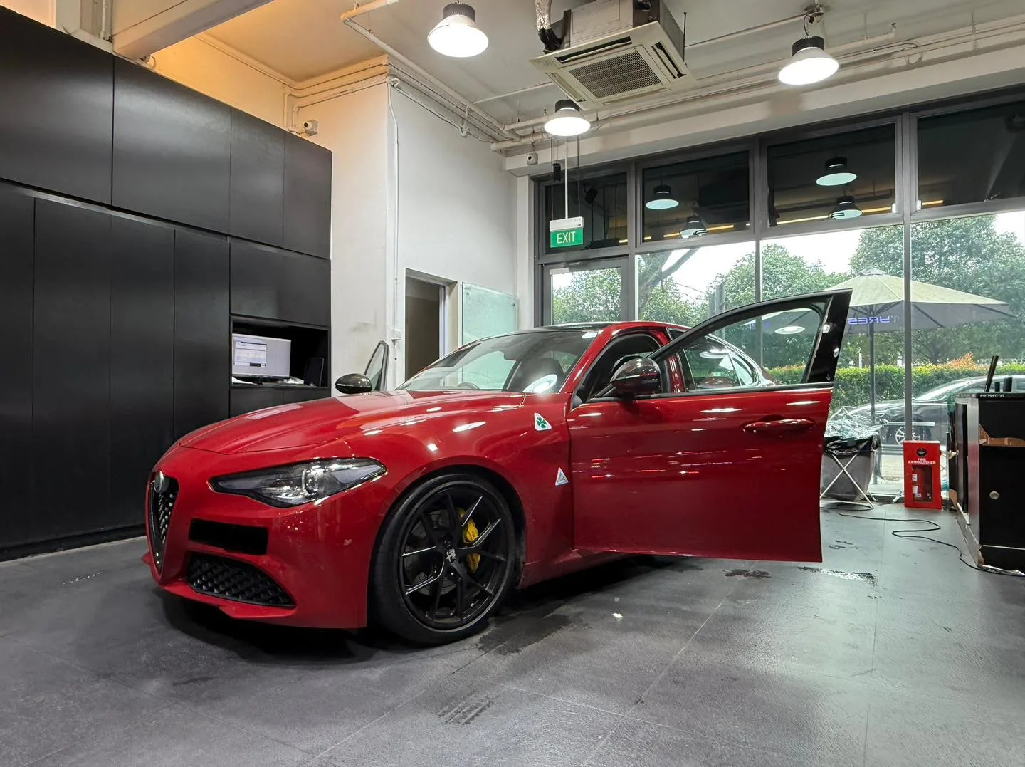 Red Alfa Romeo Giulia during window tinting inside Infratint Singapore workshop