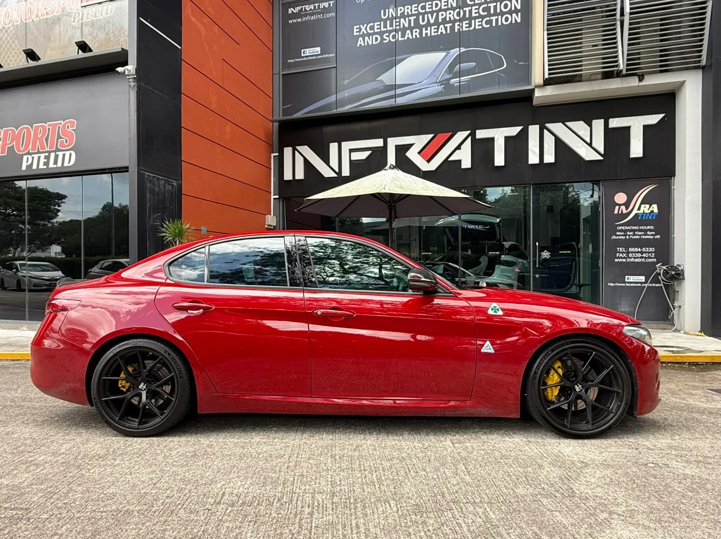 Red Alfa Romeo Giulia side profile with tinted glass and yellow calipers at Infratint Singapore