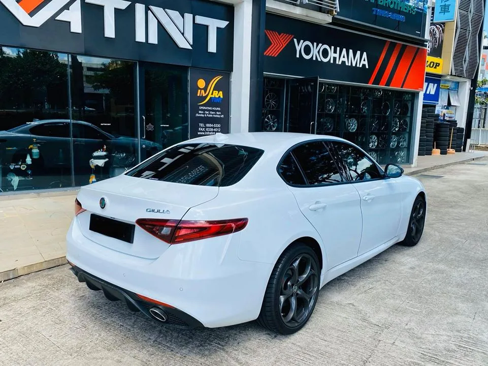 White Alfa Romeo Giulia with tinted windows outside Infratint Singapore