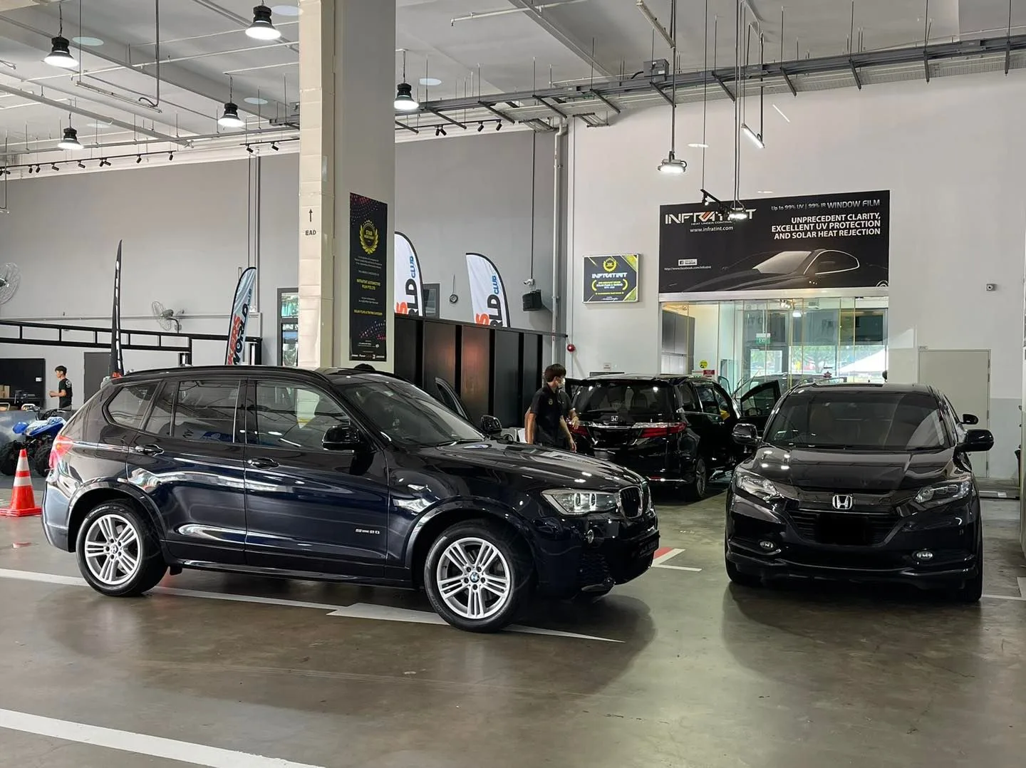 Black BMW X3 and grey Honda inside the Infratint Singapore install bay