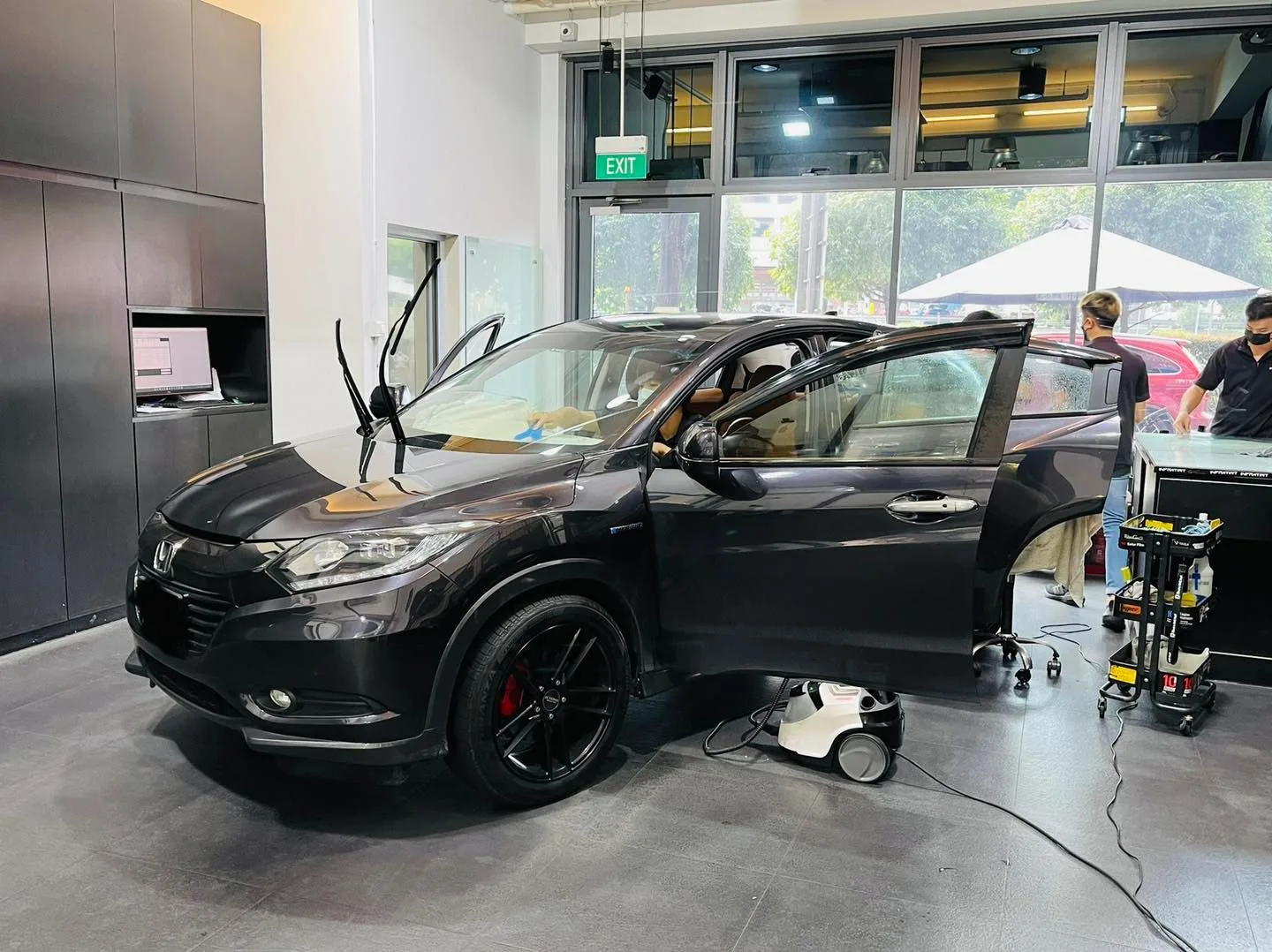 Black Honda crossover with open doors during window film install at Infratint Singapore