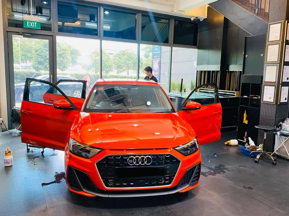 Bright red Audi A1 with doors open inside the Infratint Singapore showroom for window tinting