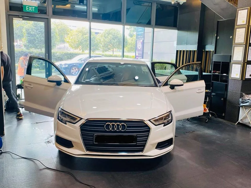 White Audi A3 with doors open during window tinting at Infratint Singapore