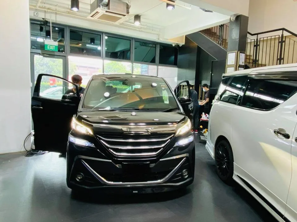 Black Toyota MPV with door open during window tinting at Infratint Singapore