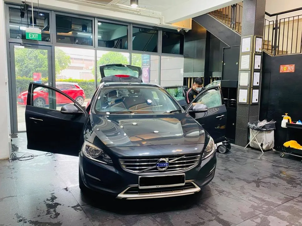 Dark grey Volvo sedan with doors open during window tinting at Infratint Singapore