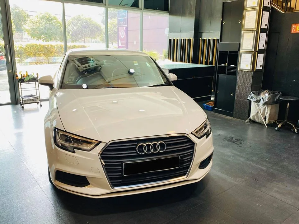 White Audi sedan parked in the showroom at Infratint Singapore for window tinting