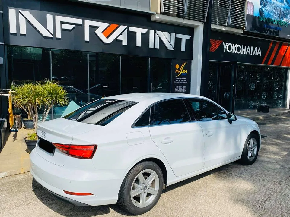 White Audi sedan outside the Infratint Singapore shopfront after window tinting