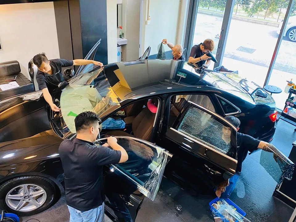 Overhead view of a dark blue Audi sedan being tinted by the team at Infratint Singapore