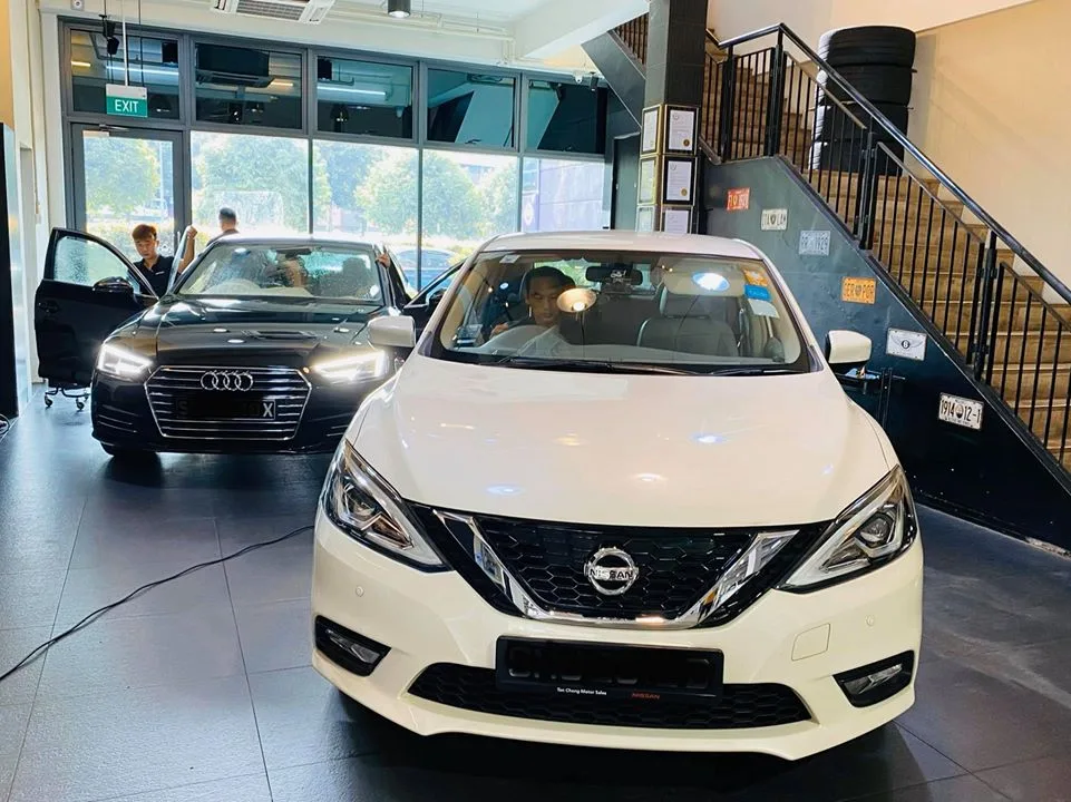White Nissan Sylphy and black Audi A4 inside the Infratint Singapore showroom for window tinting