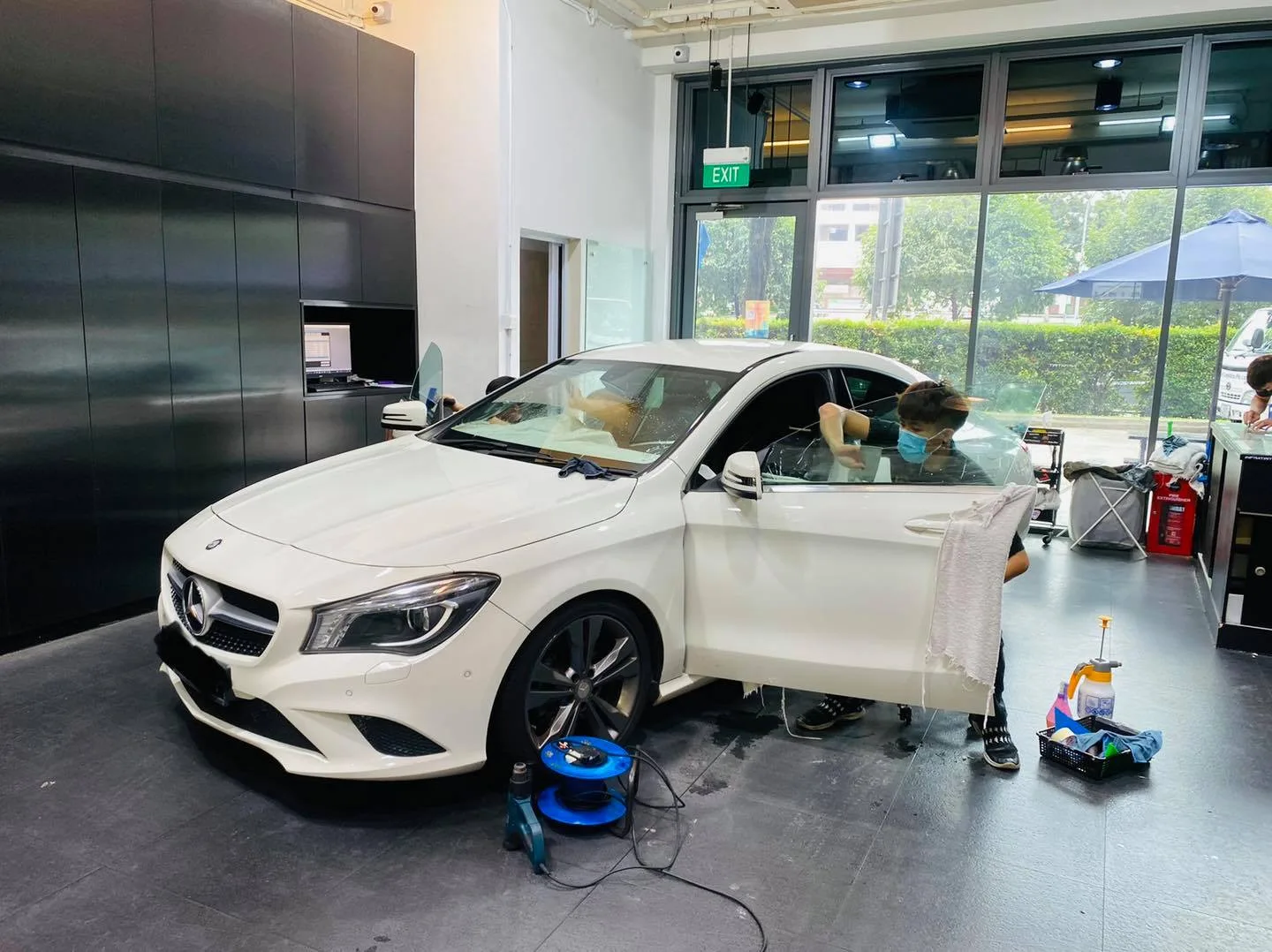 White Mercedes-Benz CLA side view during window film install at Infratint Singapore