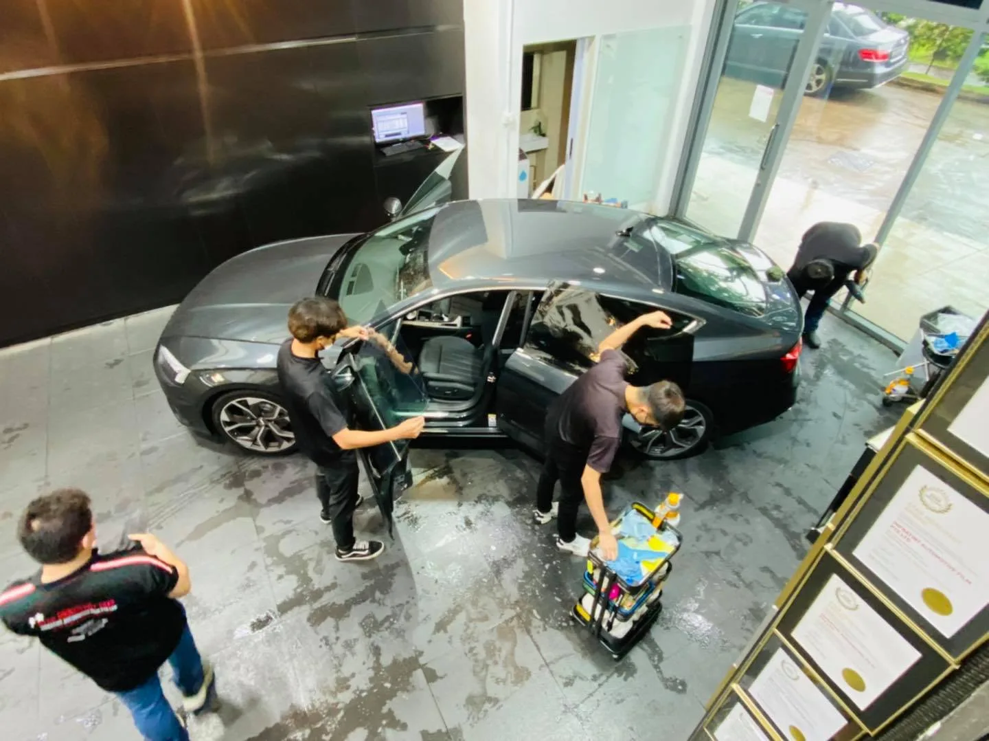 Overhead view of installers tinting a dark grey Audi sportback at Infratint Singapore