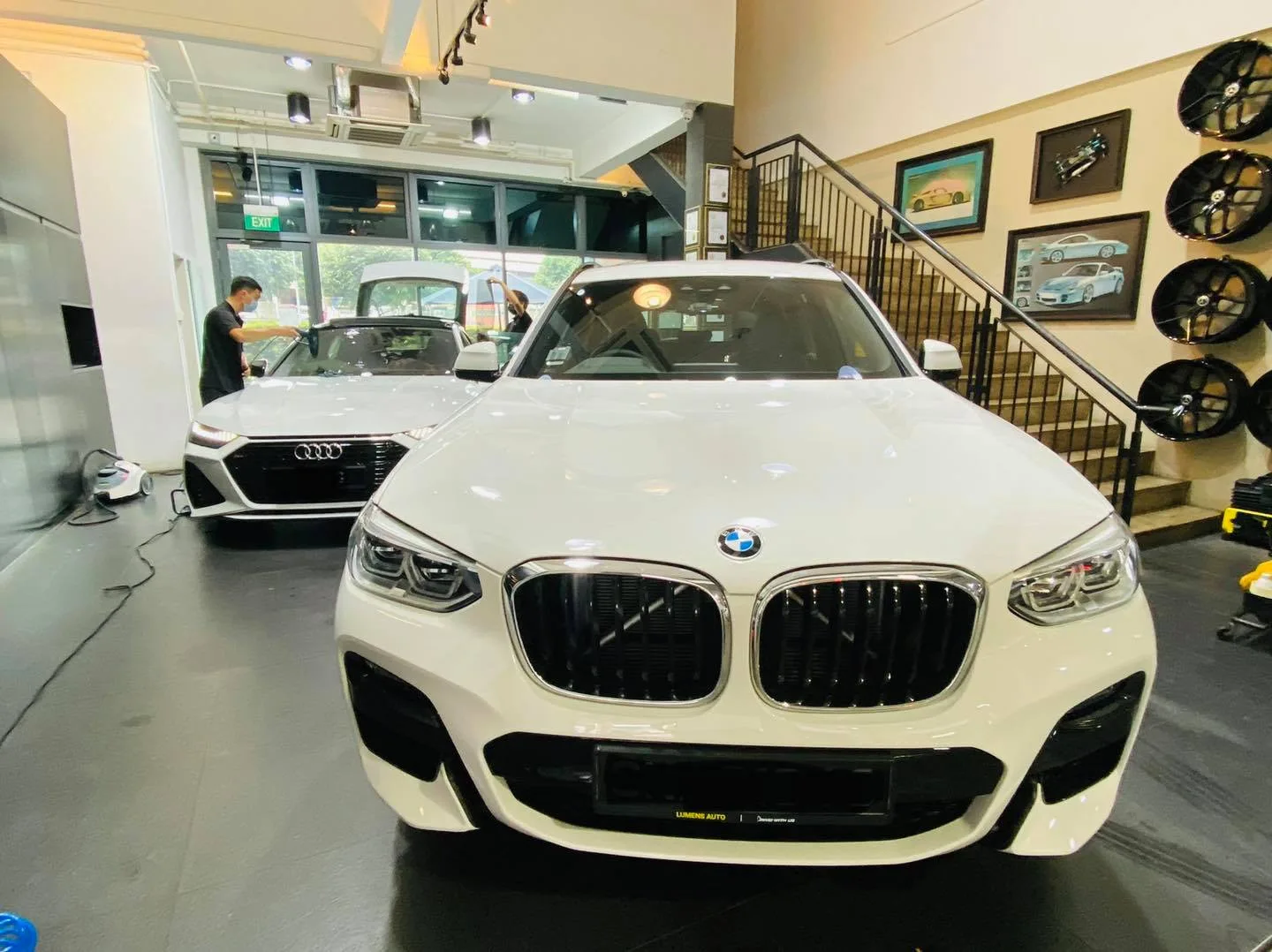 White BMW SUV and white Audi sedan inside the Infratint Singapore workshop