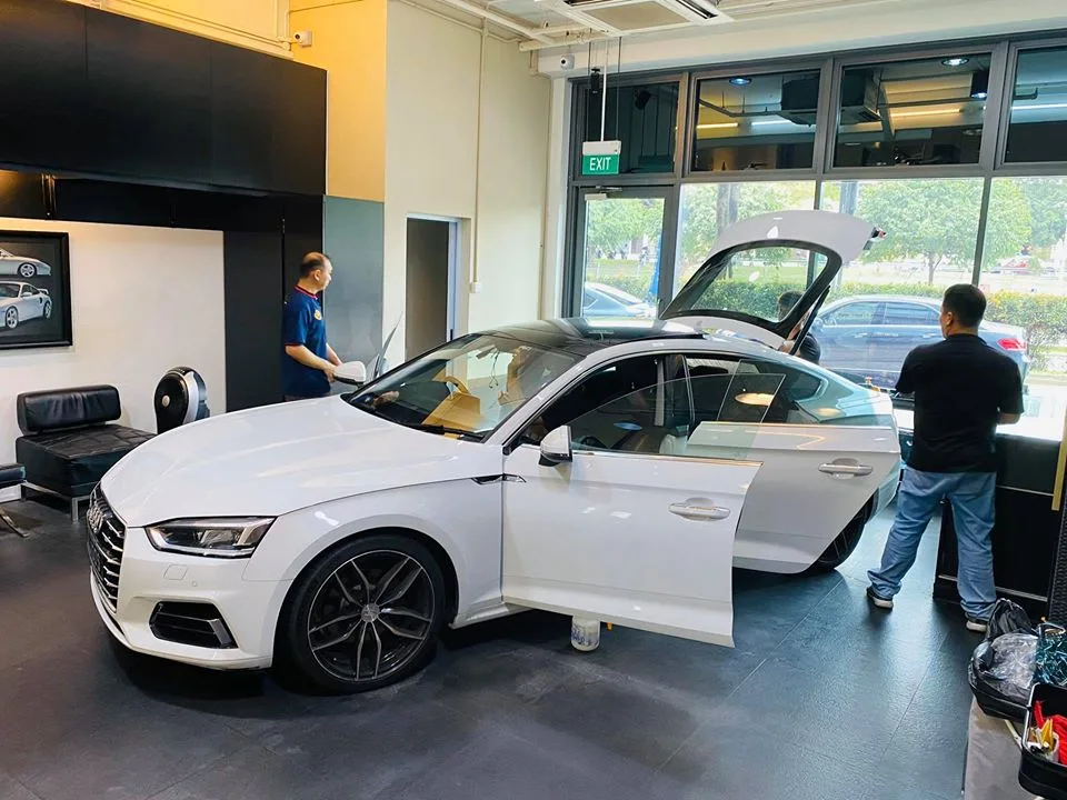 White Audi A5 Sportback with doors open during window film preparation at Infratint Singapore