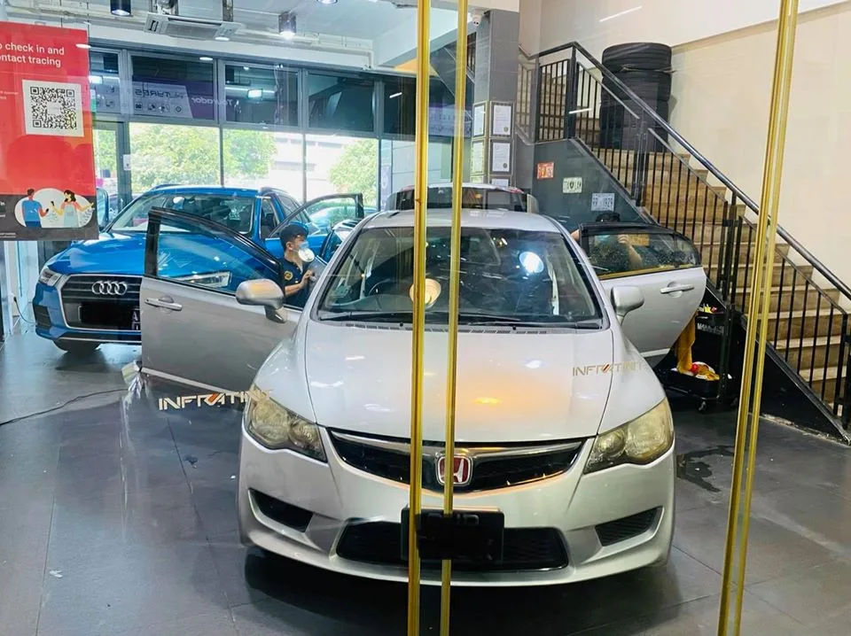 Silver Honda Civic sedan and a blue Audi during window film install at Infratint Singapore
