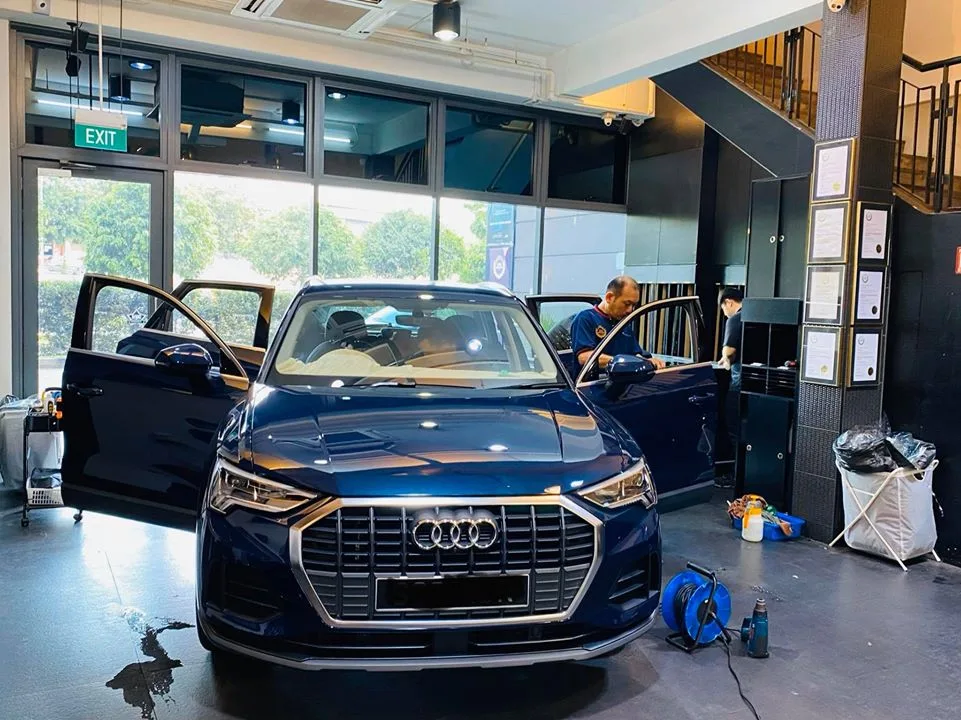 Blue Audi SUV with doors open during window tinting at Infratint Singapore