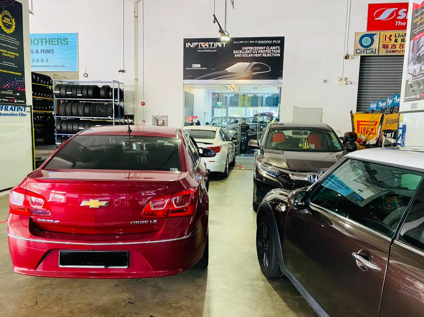Red Chevrolet Cruze in the lineup at Infratint Singapore window tinting bay