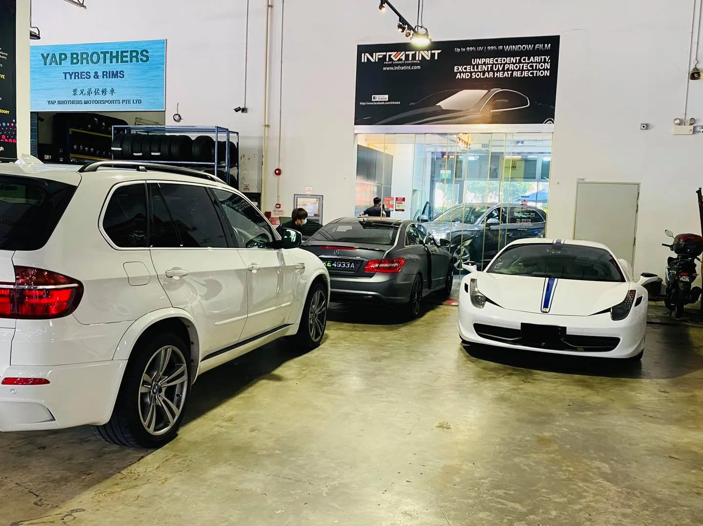 White BMW X5 and white Ferrari 458 at Infratint Singapore window tinting workshop