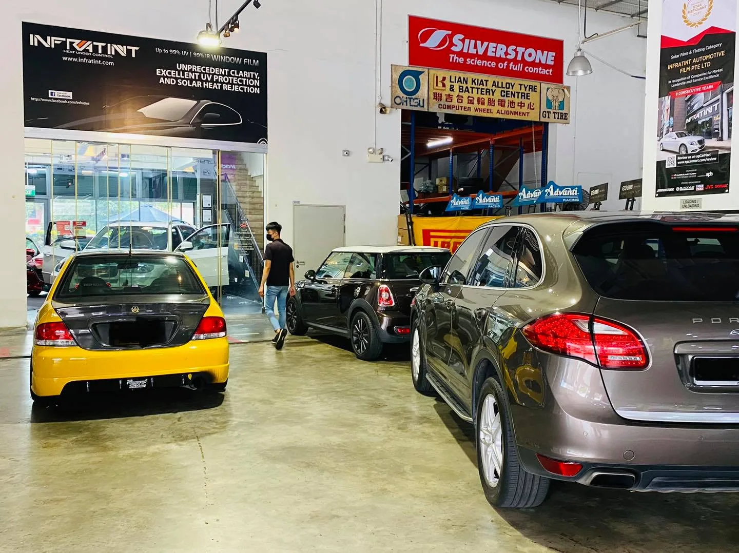 Yellow Honda and grey Porsche Cayenne lined up at Infratint Singapore window tinting workshop