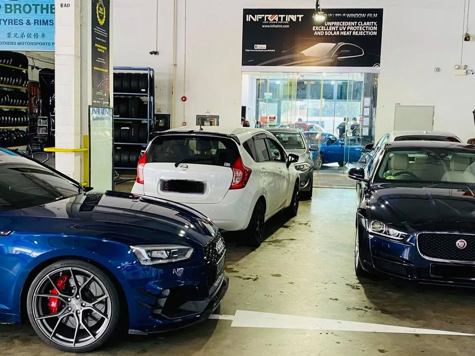 Blue Audi, white Nissan Note and dark Jaguar sedan parked in the install bay at Infratint Singapore