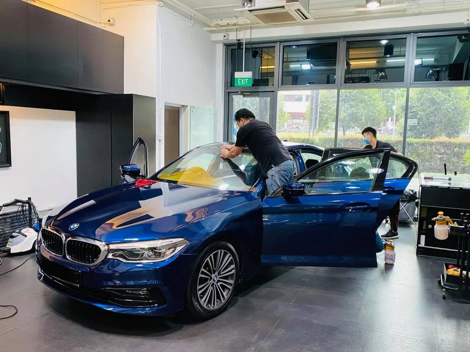 Blue BMW 5 Series with doors open during window tinting at Infratint Singapore