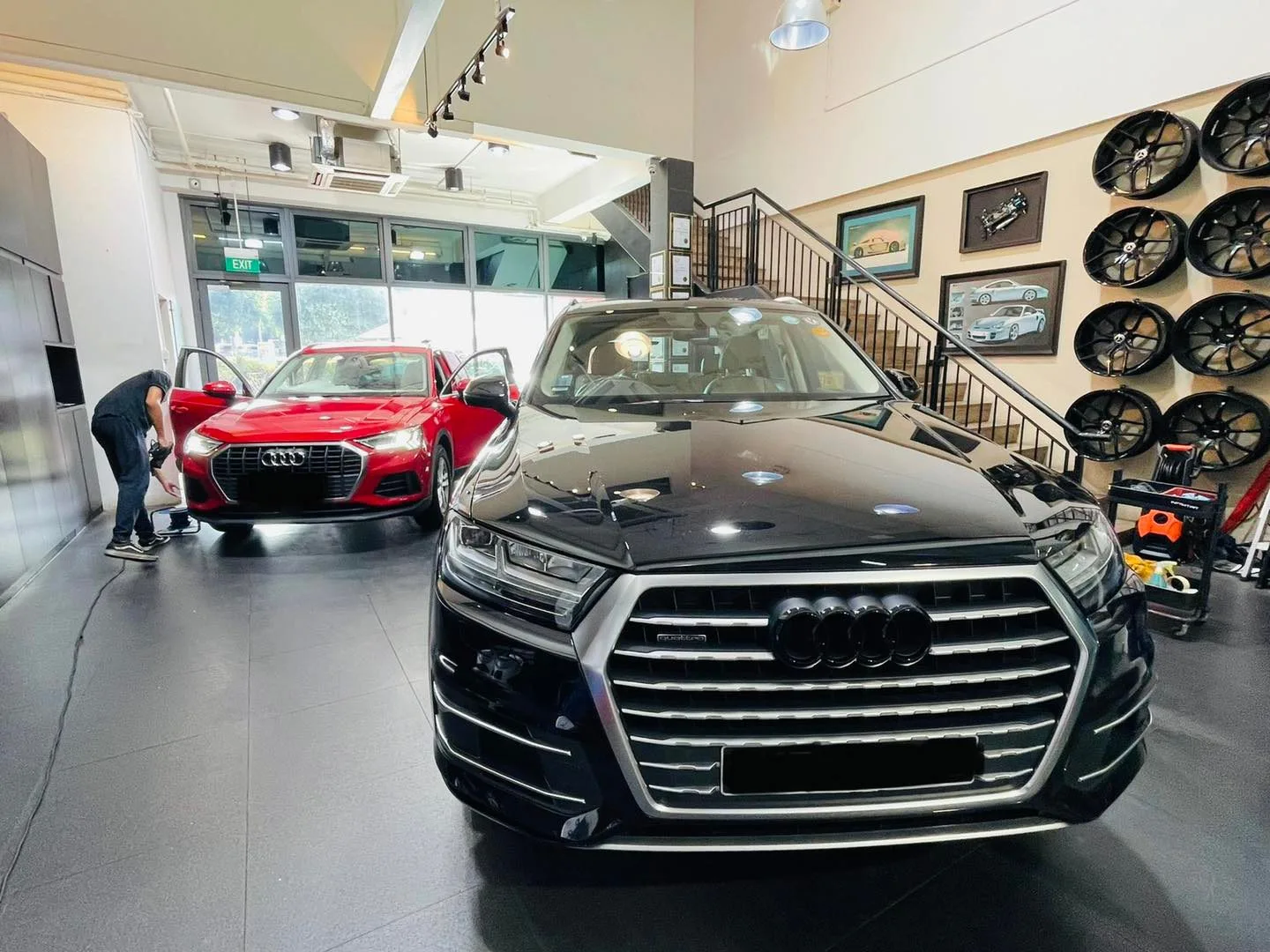 Black Audi SUV and red Audi sedan in the Infratint Singapore showroom