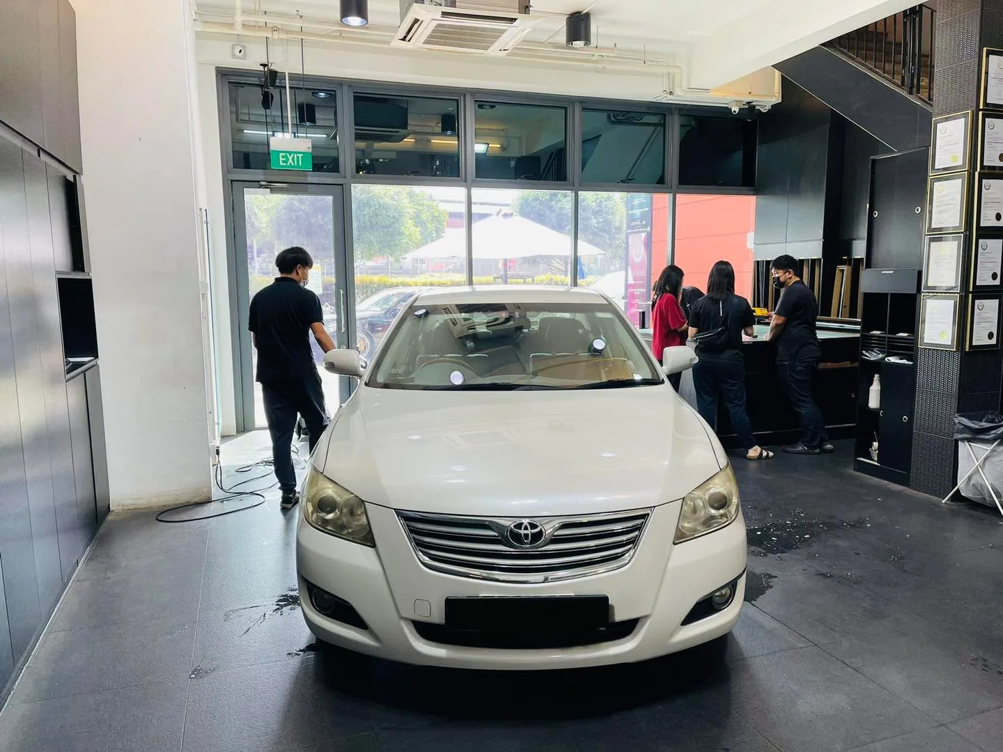 White Toyota sedan being prepared for window tinting at Infratint Singapore