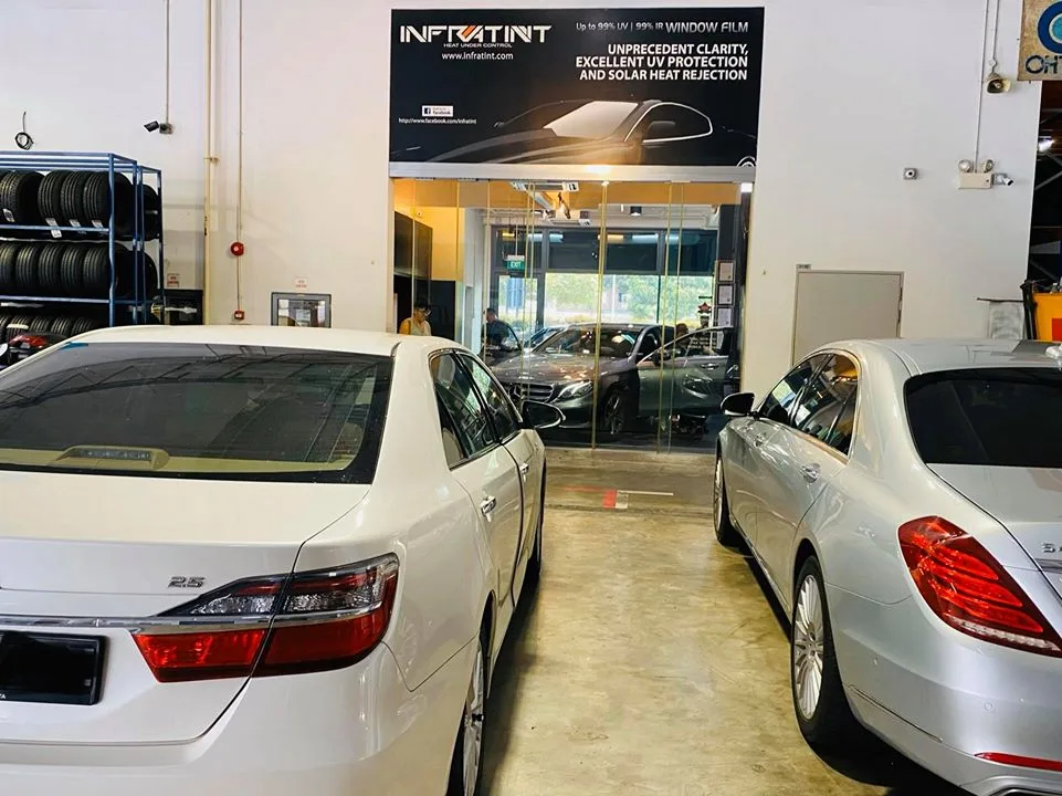 White Toyota sedan and silver Mercedes-Benz sedan waiting for tinting at Infratint Singapore
