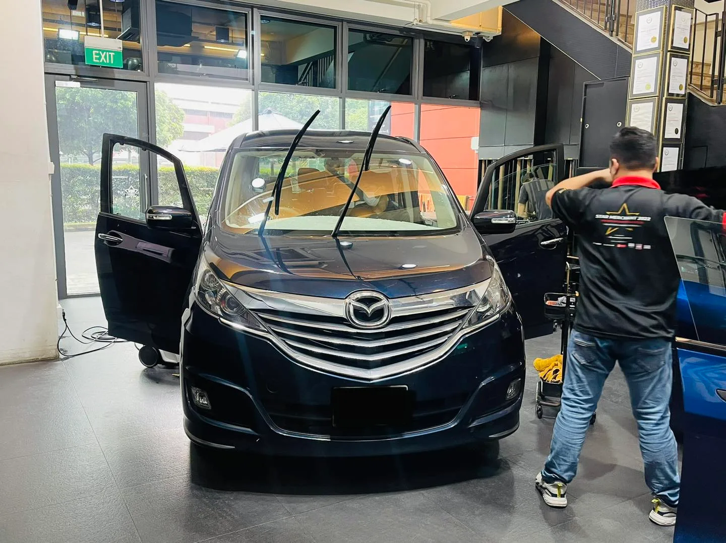 Dark blue Mazda MPV being tinted by a technician at Infratint Singapore