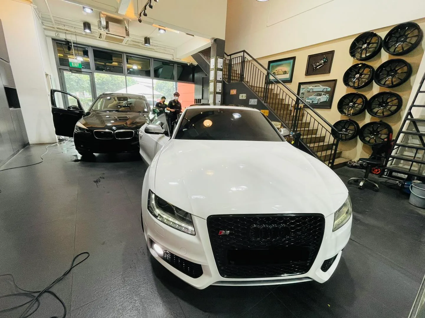 White Audi and a black BMW inside the Infratint Singapore showroom