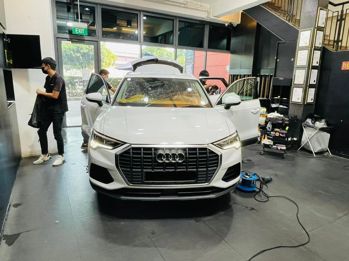 White Audi Q3 SUV front view during window film install at Infratint Singapore