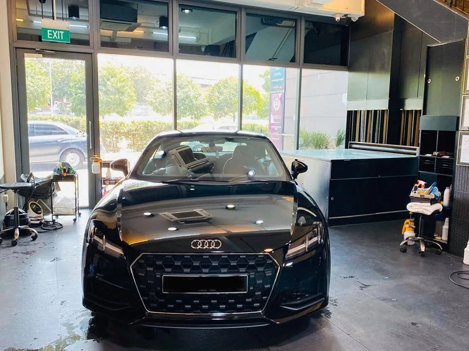 Black Audi TT coupe viewed head-on in the Infratint Singapore showroom