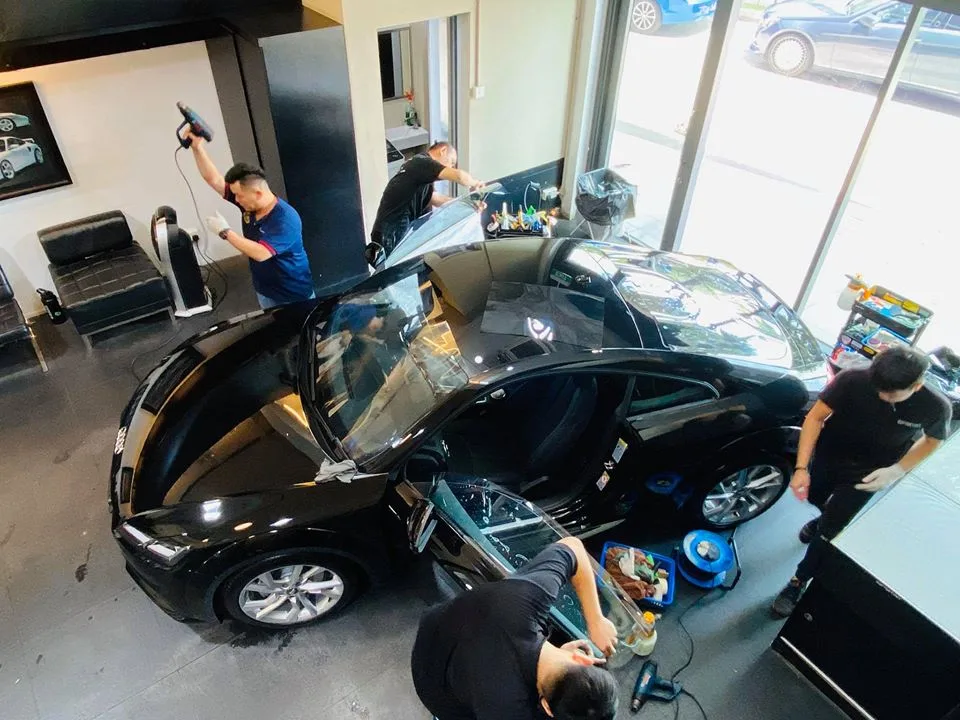 Overhead view of installers tinting a black Audi TT at Infratint Singapore