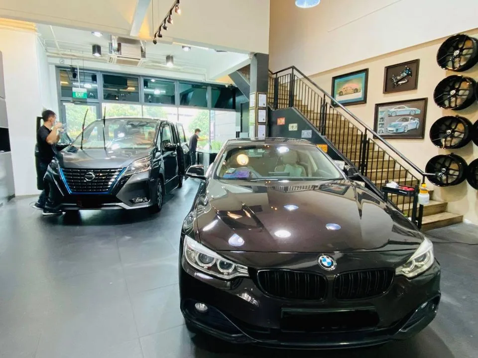 Dark BMW 4 Series and grey Nissan Serena inside the Infratint Singapore showroom
