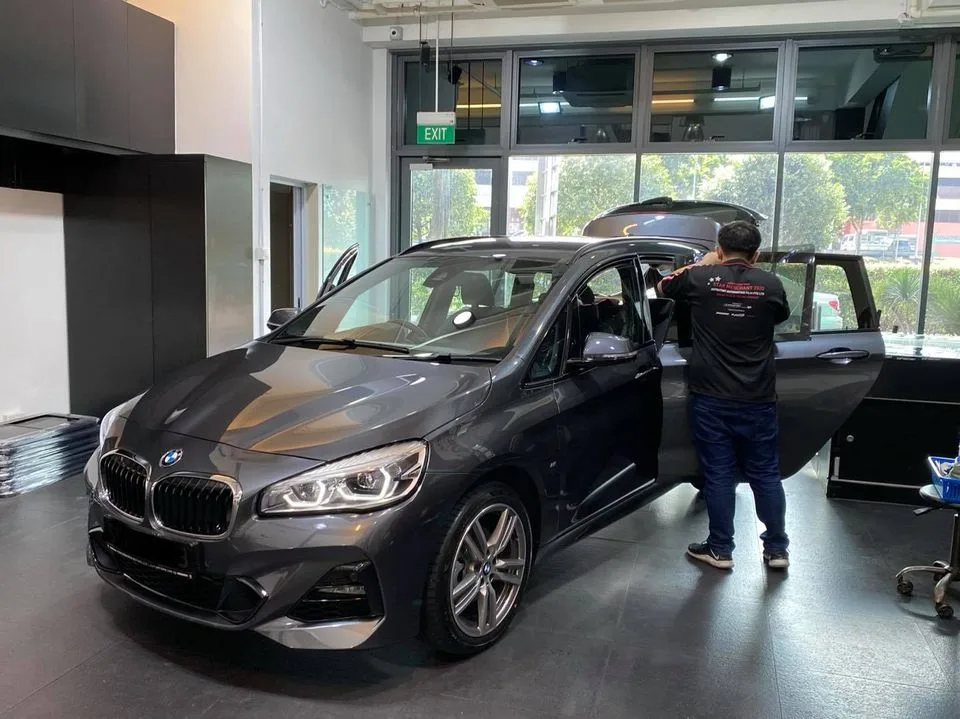 Grey BMW 2 Series tourer with doors open during window tinting at Infratint Singapore