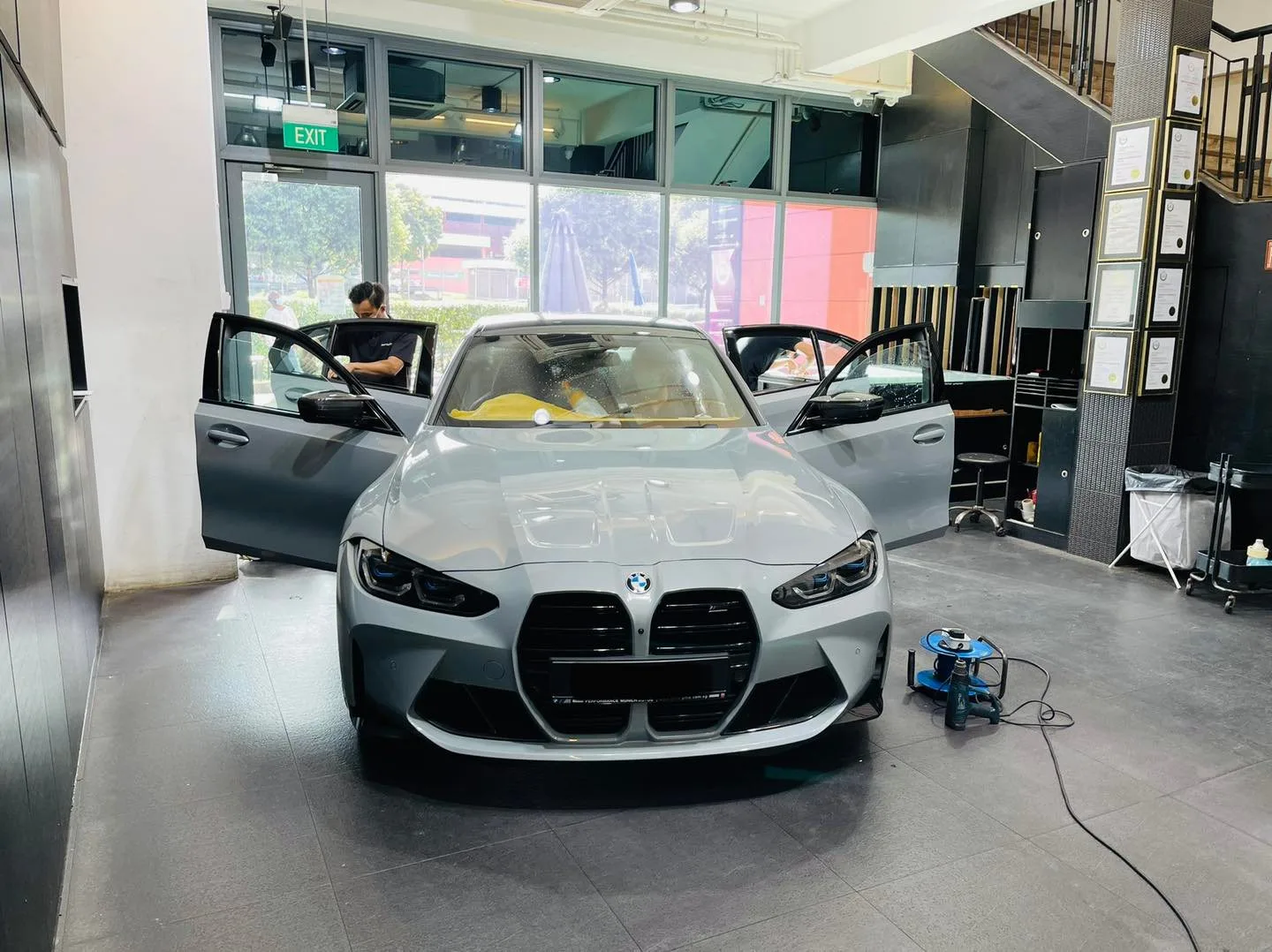 Grey BMW M3 with doors open during window tinting at Infratint Singapore