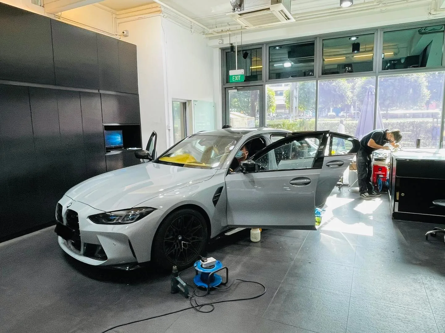 Grey BMW M3 front three-quarter view inside the Infratint Singapore workshop