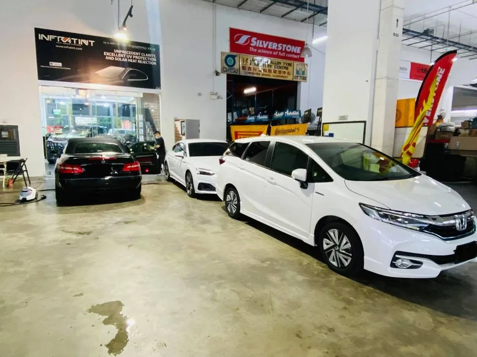 White Honda wagon and black Mercedes-Benz in the Infratint Singapore workshop