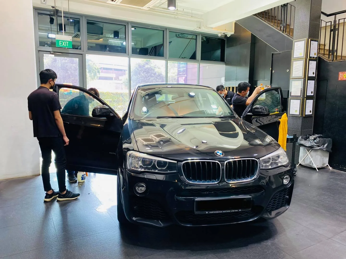 Black BMW X4 SUV with doors open for window tinting at Infratint Singapore
