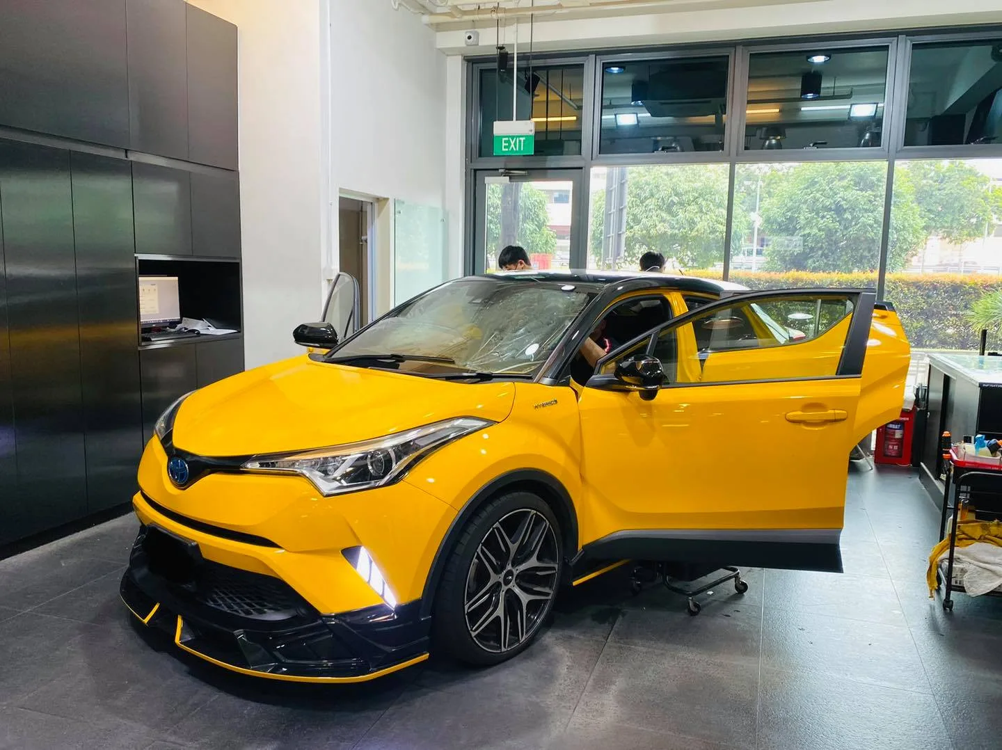 Yellow Toyota C-HR front three-quarter view during window film install at Infratint Singapore