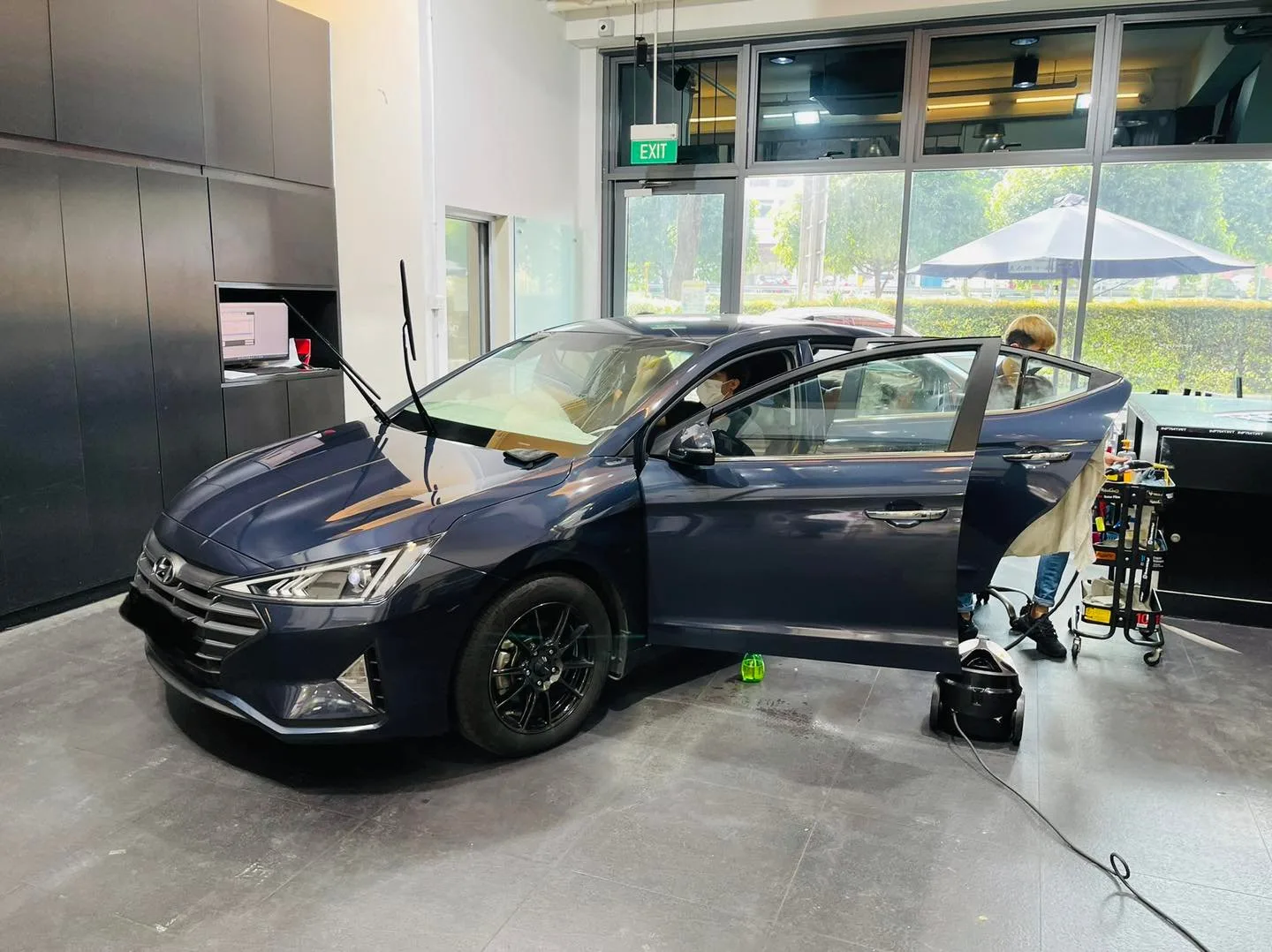 Dark blue Hyundai Avante front three-quarter during window tinting at Infratint Singapore