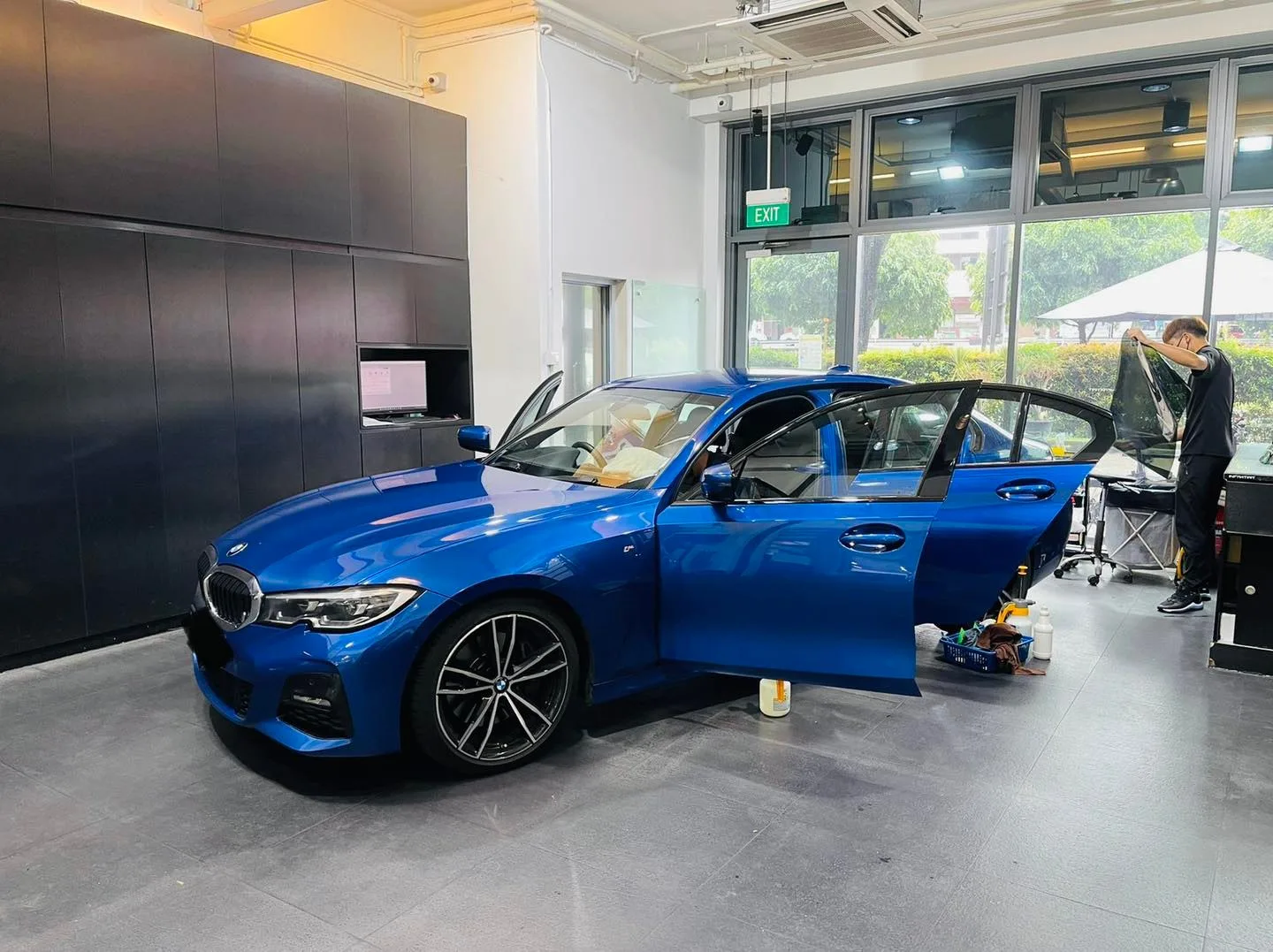 Blue BMW 3 Series front three-quarter during window tinting at Infratint Singapore