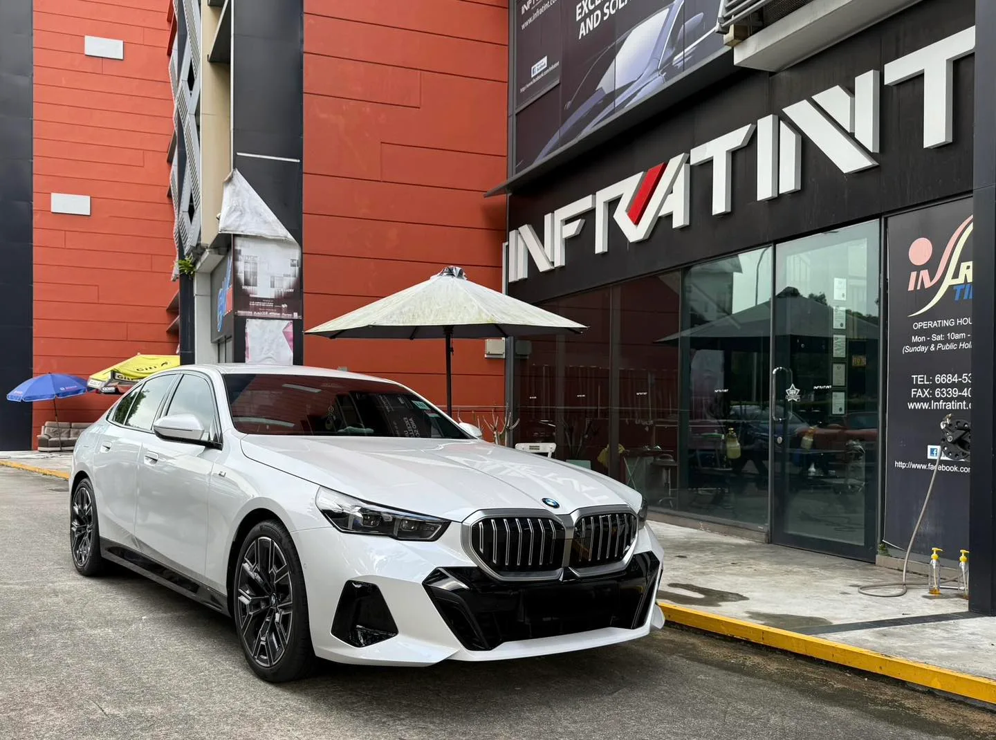 White BMW 520i front three-quarter view outside Infratint Singapore