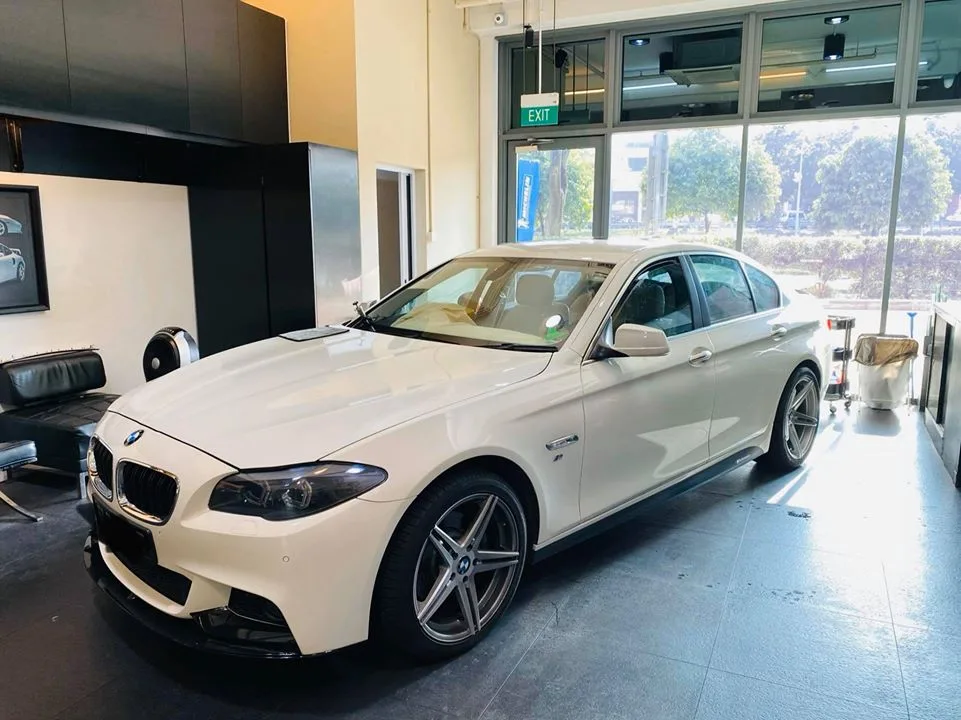 White BMW 5 Series sedan in the Infratint Singapore showroom during window tinting