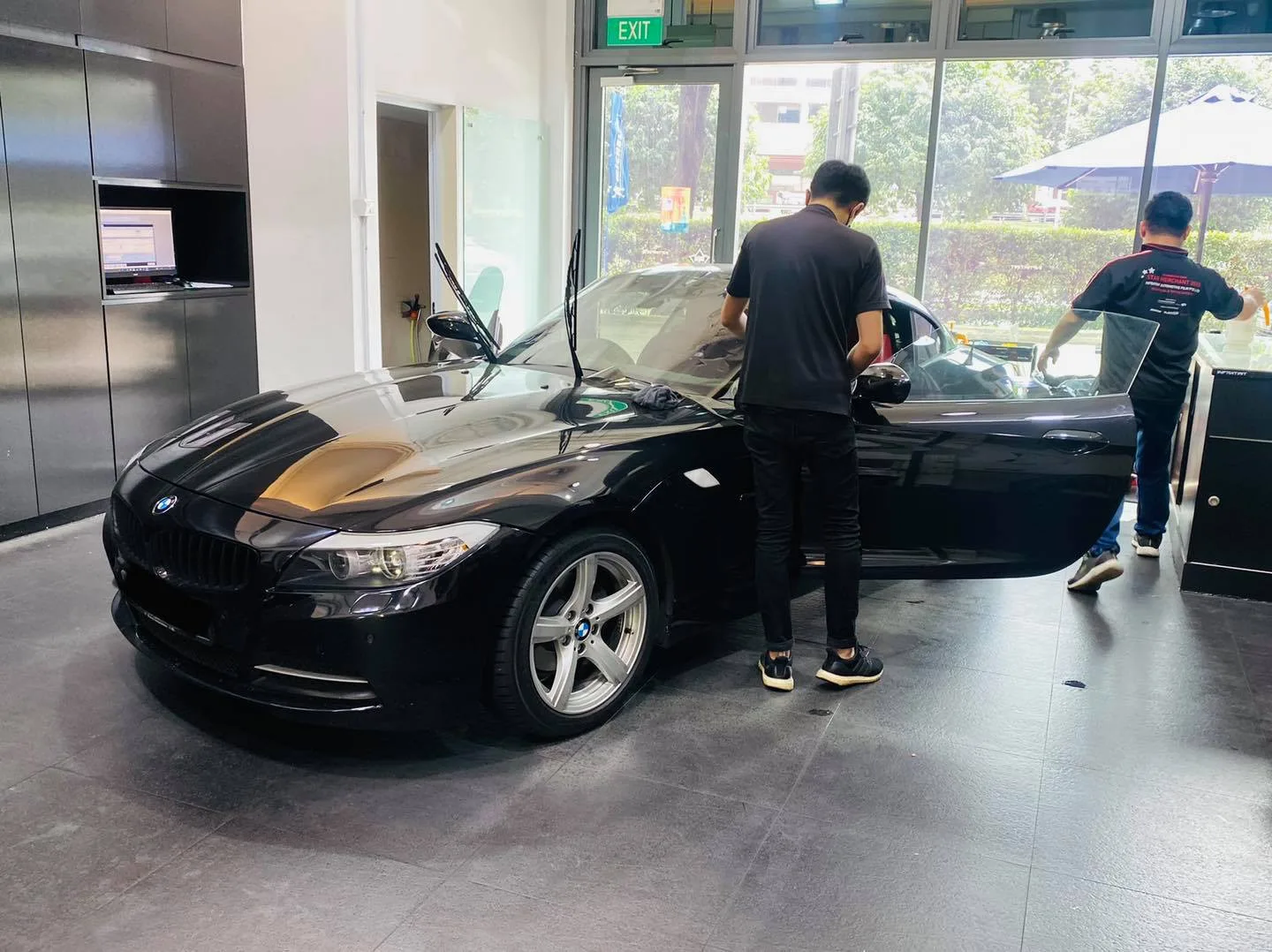 Black BMW Z4 roadster with door open during window tinting at Infratint Singapore