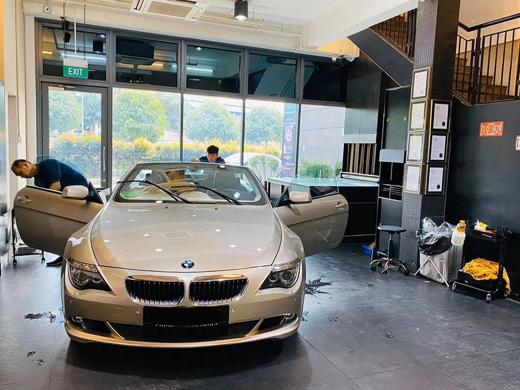 Front view of a champagne BMW 6 Series cabriolet with doors open during tinting at Infratint Singapore
